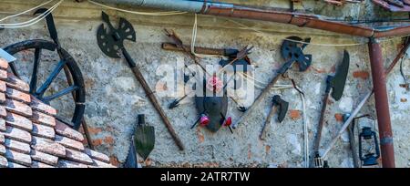 Foto von mittelalterlichen Waffen und Gegenständen, die an einer Wand am Eingang eines kleinen Museums in der Zitadelle Rasnov angebracht wurden - Rasnov, Brasov Country, Siebenbürgen Stockfoto