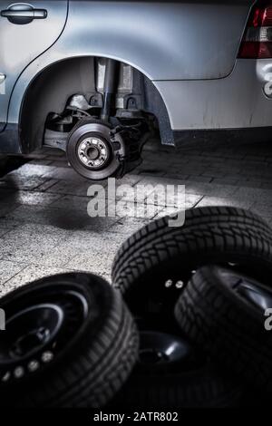 Modernes Auto in einer Garage mit geänderten Rädern/Reifen (flacher Freiheitsgrad; farbiges Bild) Stockfoto