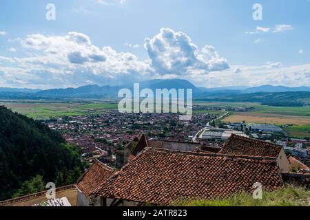 Landschaftsfoto aus der Zitadelle Rasnov, das die Stadt Rasnov und die Berge in der Ferne zeigt - Rasnov, Brasov, Siebenbürgen, Romani Stockfoto