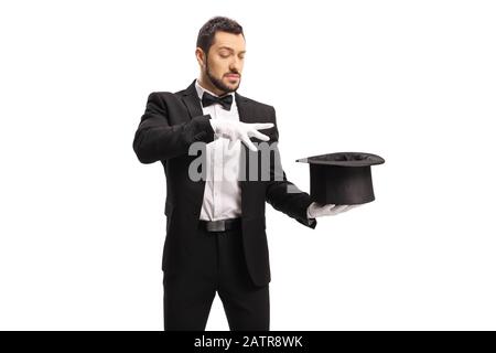 Männlicher Zauberer führt einen Trick mit Händen und einem auf weißem Hintergrund isolierten Hut durch Stockfoto