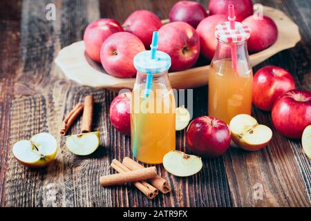 Zwei Flaschen frischer biologischer apfelwein oder apfelsaft auf dem alten Holztisch. Stockfoto