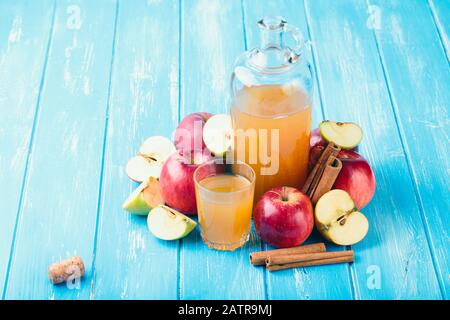 Frischer biologischer apfelwein oder apfelsaft mit blauem Hintergrund. Stockfoto