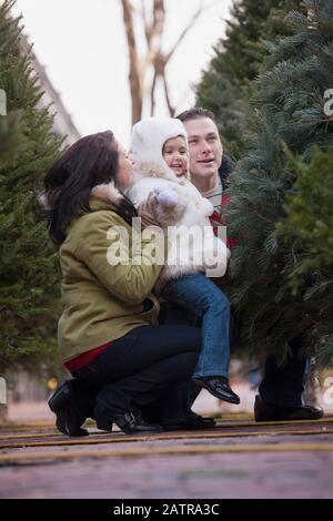 Familie mit einer jungen Tochter wählt einen frischen Weihnachtsbaum Stockfoto