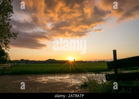 Wunderschönes Landschaftsbild von beleuchteten Wolken über der Landschaft Hollands bei Sonnenuntergang Stockfoto