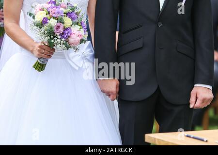 Ein Detail Foto von der Hochzeit. Das Paar hält ihre Hände während der Zeremonie. Ein Symbol für die Liebe. Stockfoto