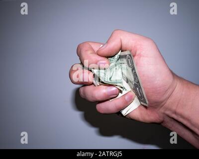 Die Hand hält und drückt die Dollar. Stockfoto