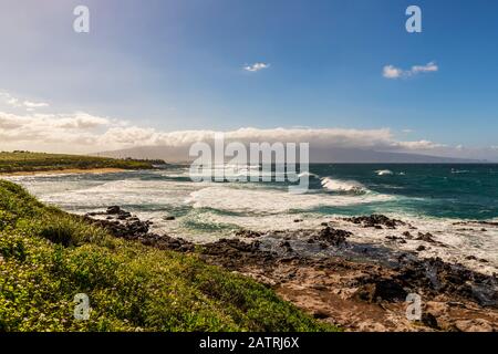 Üppiges grünes Laub und Blick auf die Wellen und den Ko'okipa Strand vom Ho'okipa Aussichtspunkt entlang der Nordküste, nahe Paia Stockfoto