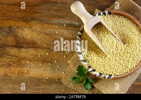 Nahaufnahme von Couscous in einer Schüssel auf Holztisch. Stockfoto