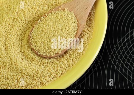 Nahaufnahme von Couscous in Holzlöffel. Stockfoto