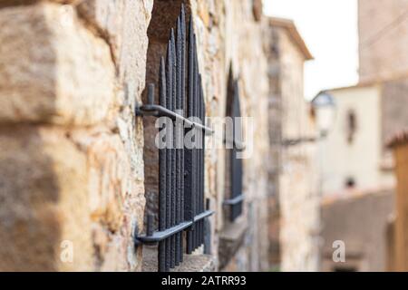 Eisengitter am Fenster eines alten Steinhauses In Spanien Stockfoto