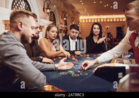 Eine Gruppe wohlhabender Jugendlicher spielt in einem Casino. Stockfoto
