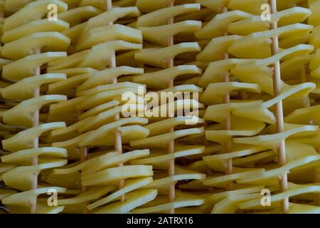 Haufen roher Spiralkartoffelspieße noch nicht gekocht, in Wasser warten Stockfoto