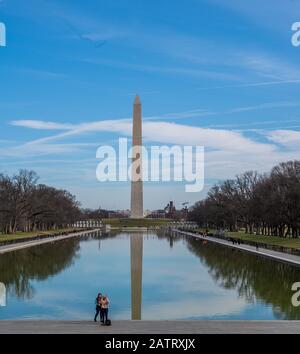 Washington DC, USA - 3. Februar 2020. Ein Foto des Washington Memorial, das Touristen umfasst, die für ein selfie am reflektierenden Pool posieren. Stockfoto