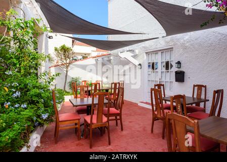 Tische mit Stühlen in einem charmanten Restaurant in Binibeca Nou, einem traditionellen spanischen Dorf auf Menorca. Spanien Stockfoto