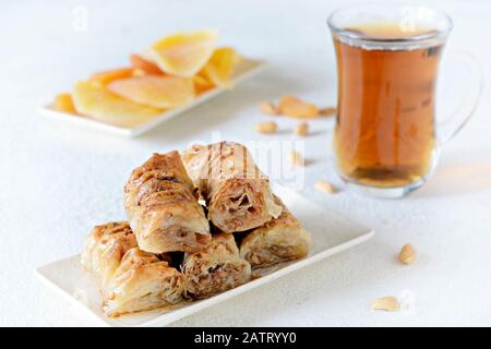 Türkisches Baklava-Dessert mit Nuss, Erdnüssen, Honigsirup mit schwarzem Tee und getrockneten Früchten, getrockneten Aprikosen und Mango. Mittelöstliche oder arabische Gerichte. Stockfoto