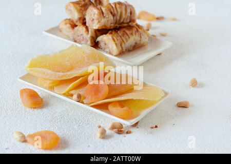 Türkisches Baklava-Dessert mit Nuss, Erdnüssen, Honigsirup mit schwarzem Tee und getrockneten Früchten, getrockneten Aprikosen und Mango. Mittelöstliche oder arabische Gerichte. Stockfoto