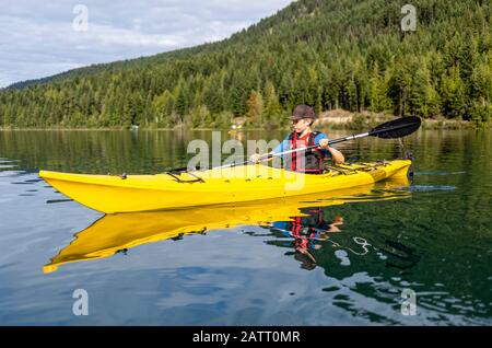 Ein Teenager Kajak auf White Lake, White Lake Provincial Park; British Columbia, Kanada Stockfoto