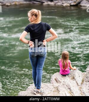 Zwei Schwestern verbringen Zeit zusammen am Rande eines Flusses; British Columbia, Kanada Stockfoto