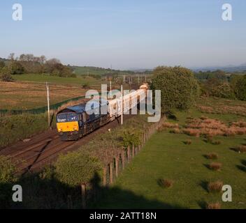 Diesellokomotive der Direct-Rail-Services-Klasse 66 auf der Westküsten-Hauptstrecke in Cumbria mit einem Güterzug, der Materialien für Network Rail trägt Stockfoto