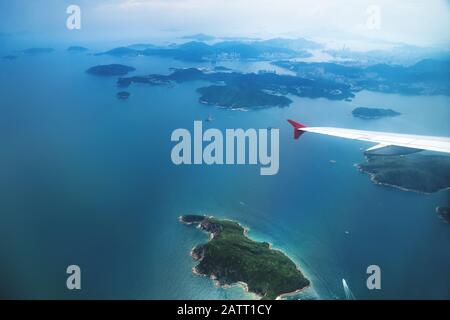 Luftaufnahme der Inseln in Hongkong von einem fliegenden Flugzeug mit Flügel, China Stockfoto