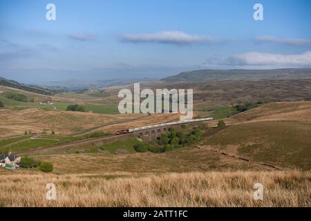 DB Cargo Class 66 Locomotive 66008 Passing Lunds Viaduct (Garsdale) auf der landschaftlich reizvollen Strecke Settle to Carlisle Railway mit einem Güterzug, der Zement transportiert Stockfoto