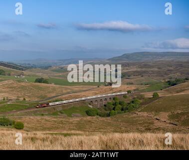 DB Cargo Class 66 Locomotive 66008 Passing Lunds Viaduct (Garsdale) auf der landschaftlich reizvollen Strecke Settle to Carlisle Railway mit einem Güterzug, der Zement transportiert Stockfoto