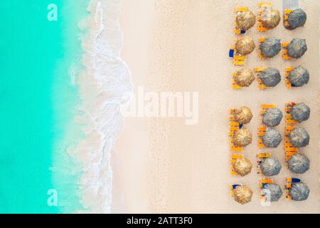 Antenne top Aussicht auf den Strand. Regenschirme, Sand und Meer Wellen Stockfoto