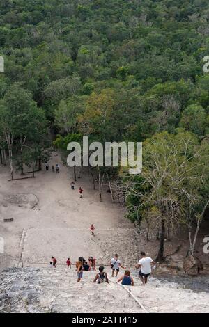 Die Menschen klettern auf die steilen Stufen der Nohoch Mul Pyramide bei den alten Maya-Ruinen in Coba, Quintana Roo, Mexiko. Stockfoto