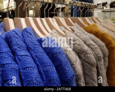 Wollpullover hängen an Bügeln in einem Bekleidungsgeschäft Stockfoto