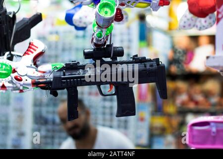 Automatische Waffe aus Plastikspielzeug. Er wirft Plastikperlen. Vor dem Laden hängend fotografiert. Nahaufnahme Stockfoto