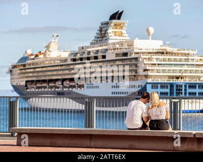 Ein junges Paar sitzt vor einem Kreuzfahrtschiff im Hafen von Funchal, Madeira. Stockfoto