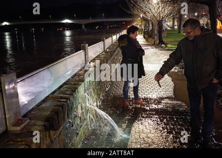 Zell, Deutschland. Februar 2020. Ortsbewohner Eberhard filet mit seinem Handy eine Stelle an der Hochwasserschutzwand in Zell (Rheinland-Pfalz), wo das Moselwasser in die Mauer eindringt. Wird die Mauer überschwemmt, stehen Teile der Stadt unter Wasser. Credit: Thomas Frey / dpa / Alamy Live News Stockfoto