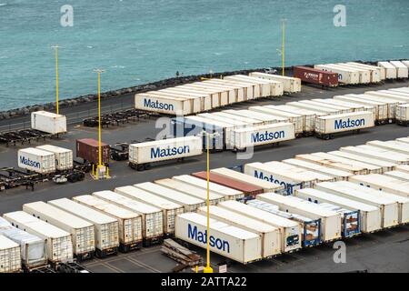 Kahului, Maui, Hawaii, USA. - 13. Januar 2020: Nahaufnahme des Matson Schiffscontainer Yard, gefüllt mit weißen Kisten auf Anhängern am Kai an der Grenze zu Azurblau Stockfoto