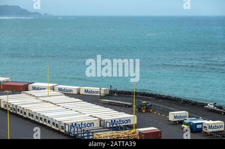 Kahului, Maui, Hawaii, USA. - 13. Januar 2020: Matson Schiffscontainer Hof gefüllt mit weißen Kisten auf Anhängern am Kai, der an den azurblauen Ozean grenzt. Stockfoto