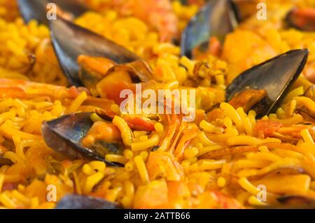 Nahaufnahme einer typischen Mahlzeit im spanischen Osten, der fideuà mit verschiedenen Meeresfrüchten, Fisch und Nudeln Stockfoto