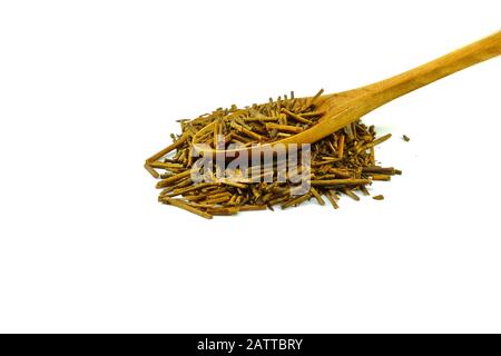 Grüner japanischer Kukicha-Tee (Twig oder Stiel oder Stick), der bei makrobiotischer Ernährung beliebt ist. Kukicha auf einem Holzlöffel. Stockfoto