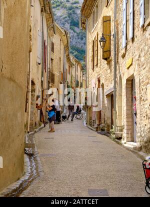 Straßenszene der St Guilhem le Desert, Fußgängerzone mit alten historischen Häusern auf beiden Seiten. St-Guilhem, Frankreich. Mai 2019 Stockfoto