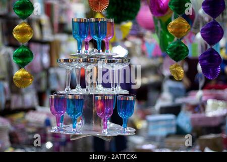 Dreifach gestufter Ständer und darauf eine Weingläser aus Kunststoff. Nahaufnahme. Zum Verkauf vor dem Laden. Geburtstag an besonderen Tagen verwendet wird. Stockfoto