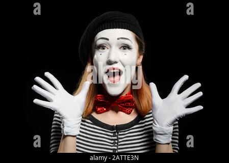 Fröhliche weibliche Mime auf schwarzem Hintergrund. Süße Schauspielerin Stockfoto