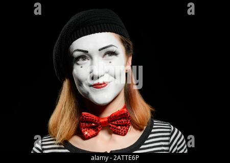 Schöne weibliche MIME auf schwarzem Hintergrund. Frau, gekleidet mit gestreiftem T-Shirt Stockfoto