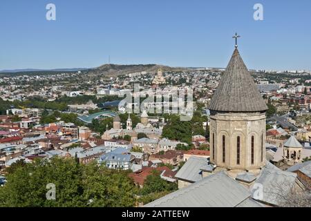 Tiflis: Kirche Sankt Nikolaus mit Panoramablick auf das Stadtzentrum vom Sololaki-Hügel im Hintergrund (Georgien) Stockfoto