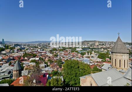 Tiflis: Kirche Sankt Nikolaus mit Panoramablick auf das Stadtzentrum vom Sololaki-Hügel im Hintergrund (Georgien) Stockfoto