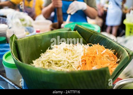 Geschnittene unreife Papaya und Karotten sind die Zutaten für die Herstellung von Som Tam, Thai Papaya Salat Stockfoto