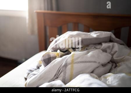 Unordentliche Bettdecke auf einem Bett Stockfoto