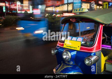 Tuk Tuk, ein Taxi mit 3 Rädern in Thailand, ist nachts in Bangkok unterwegs. Ein Wort auf dem Nummernschild ist ein thailändisches Wort „Krungthepmahanakhon“, das Bangkok bedeutet. Stockfoto