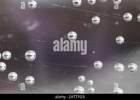 Nahaufnahme von Blasen, die durch das Glas in einer Tasse Wasser gesehen werden. Stockfoto