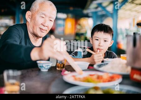 Granfather Ehjoy Dinner mit ihrem Enkel im Restaurant Stockfoto