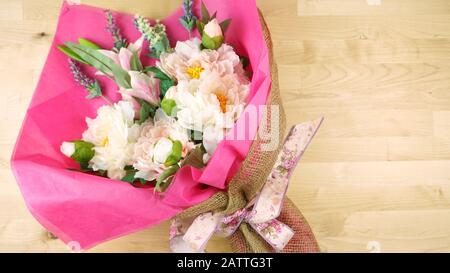 Blumen in rosafarbenem Gewebe und hessisches modernes Trend-Wrapping flach lagen für Muttertag, Geburtstag oder Valentinstag Feiern. Negative Kopie sp Stockfoto
