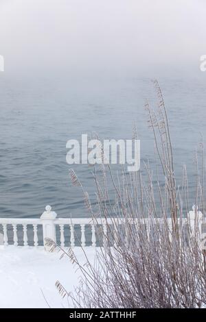 Frost- und eisbedeckte Baluster an einem Seeufer im Winter. Baikalsee, Listvyanka, Sibirien, Russland. Stockfoto