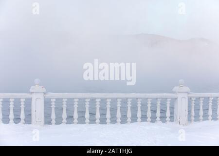 Frost- und eisbedeckte Baluster an einem Seeufer im Winter. Baikalsee, Listvyanka, Sibirien, Russland. Stockfoto